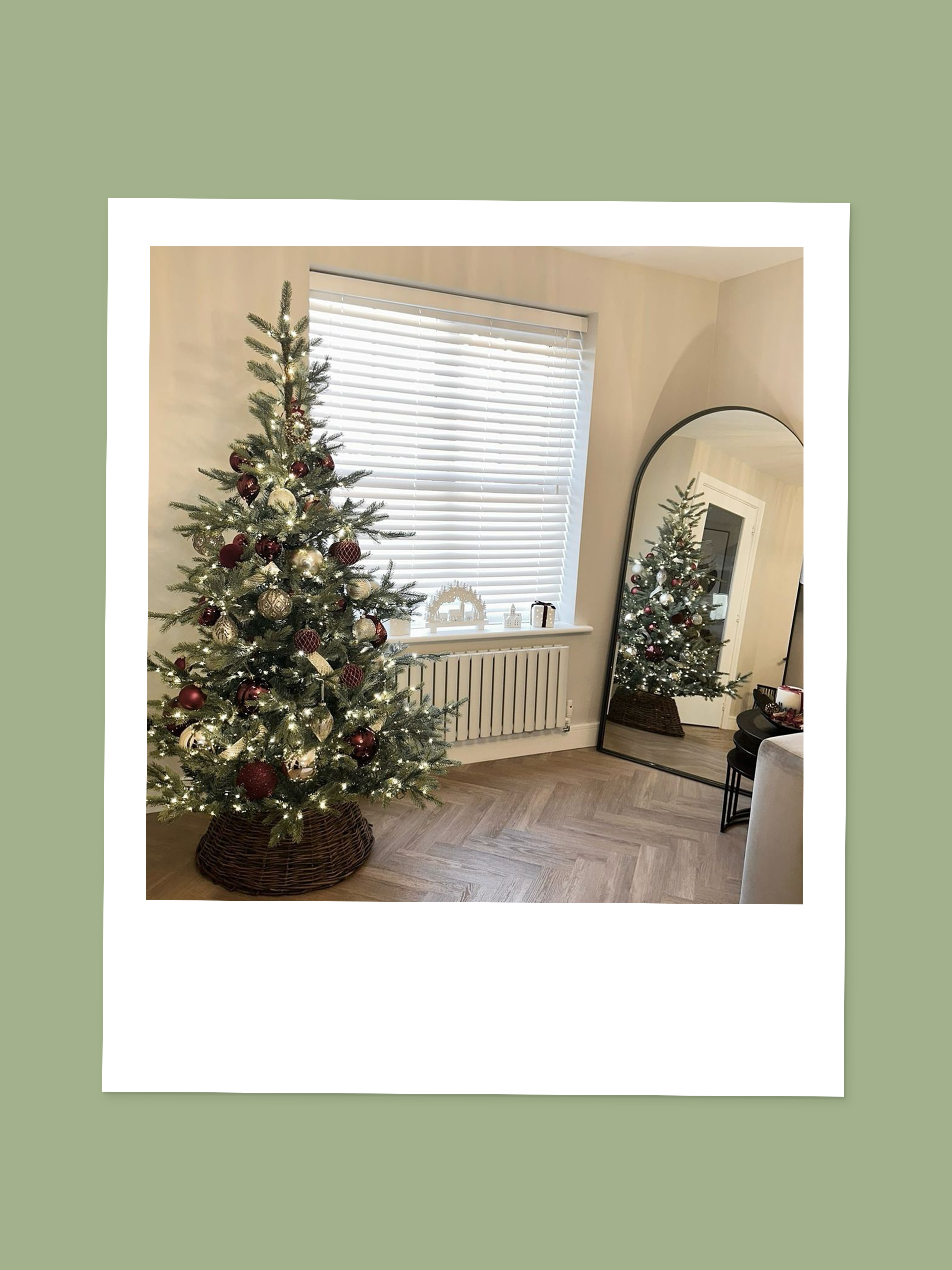 Polaroid image of a Christmas tree with red and white decorations and a brown tree skirt