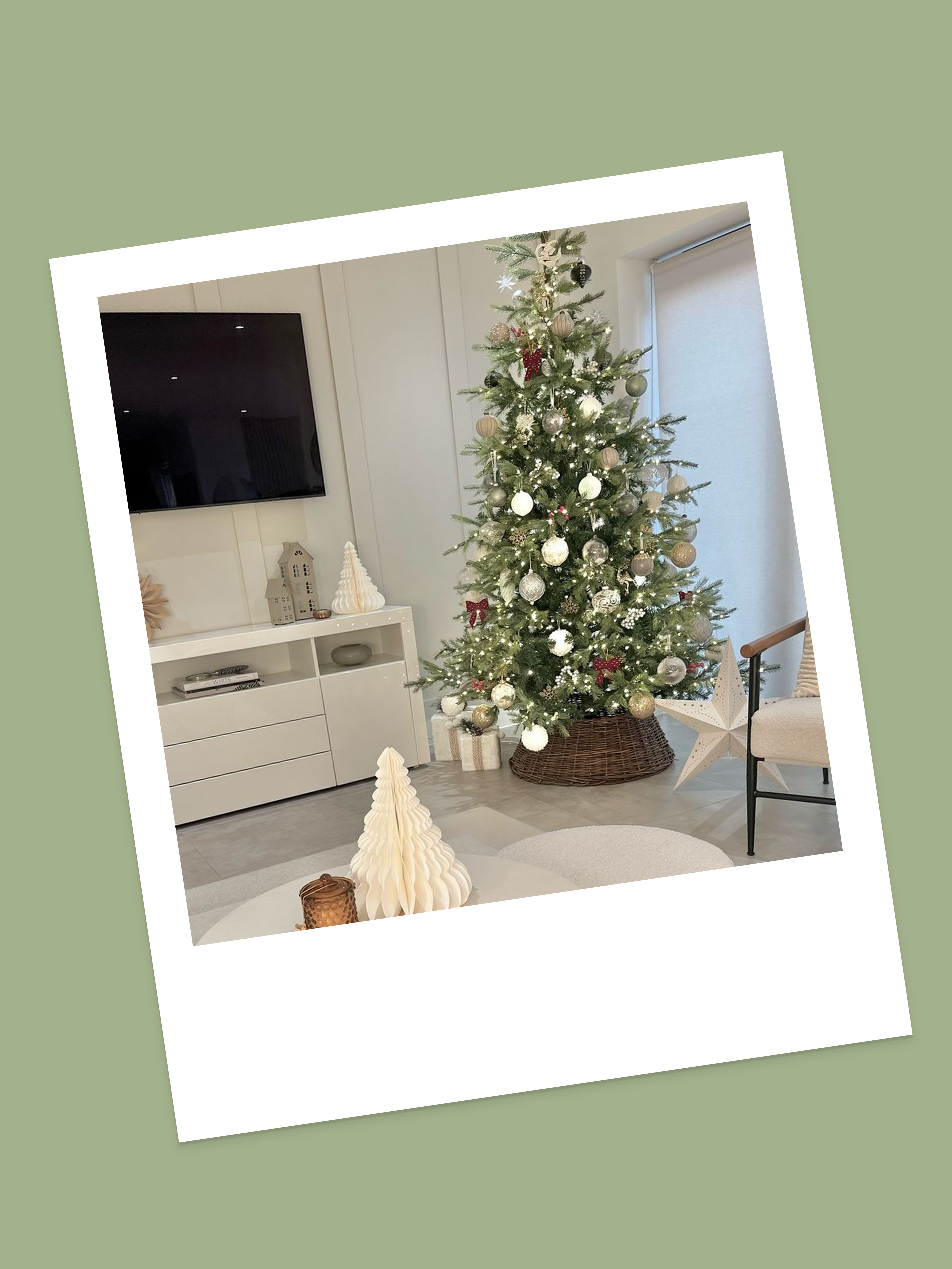 Polaroid image of a Christmas tree with white and gold decorations and a brown tree skirt