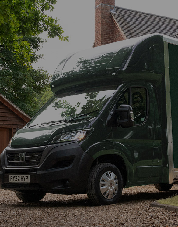 A White Stores dark green delivery van outside a customer house.