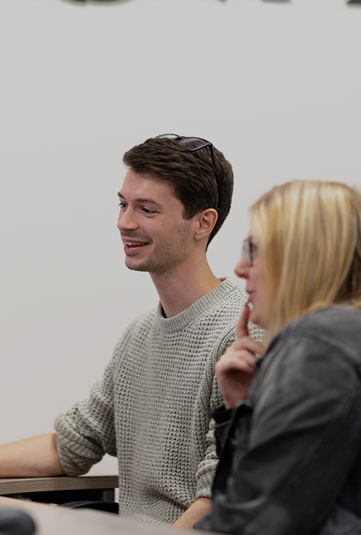 Two White Stores employees looking at a computer screen, smiling.