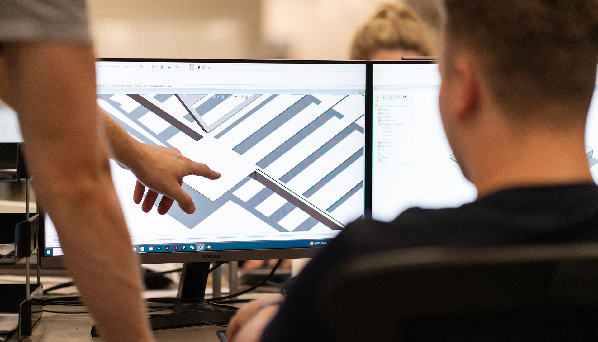 The design team looking at a computer at drawings of new garden sets.